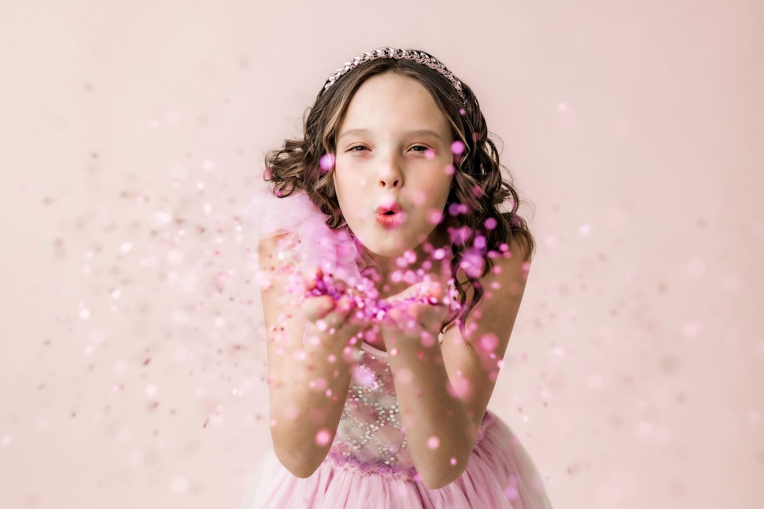 preteen girl blowing pink glitter