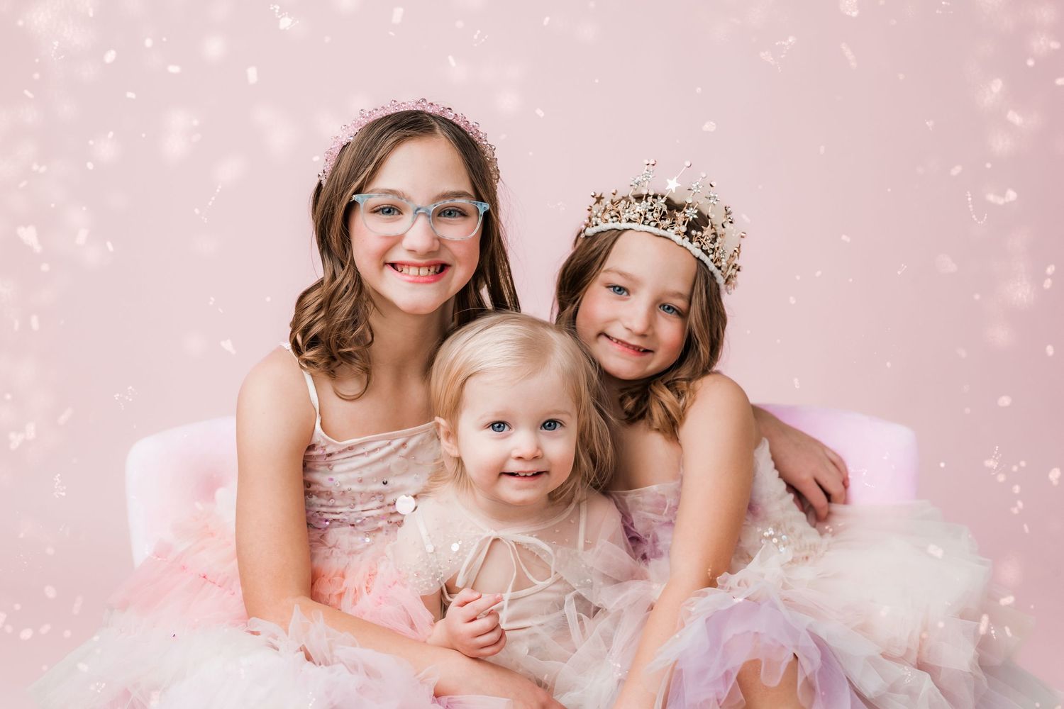 three little girls dressed in dresses and tiaras