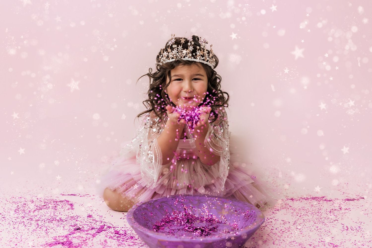 little girl in princess dress playing with glitter in a tiara
