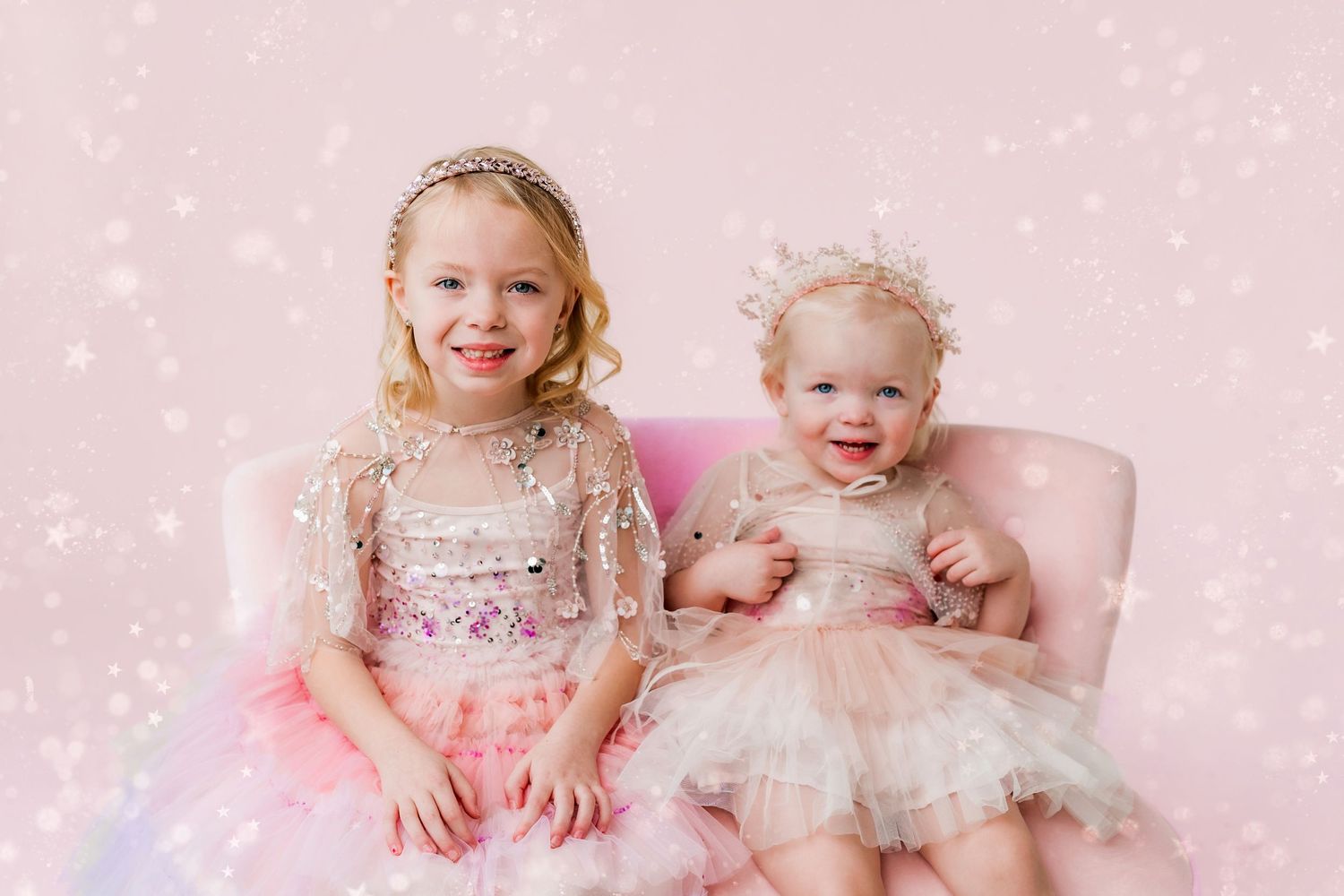 two sisters dressed in dresses and tiaras
