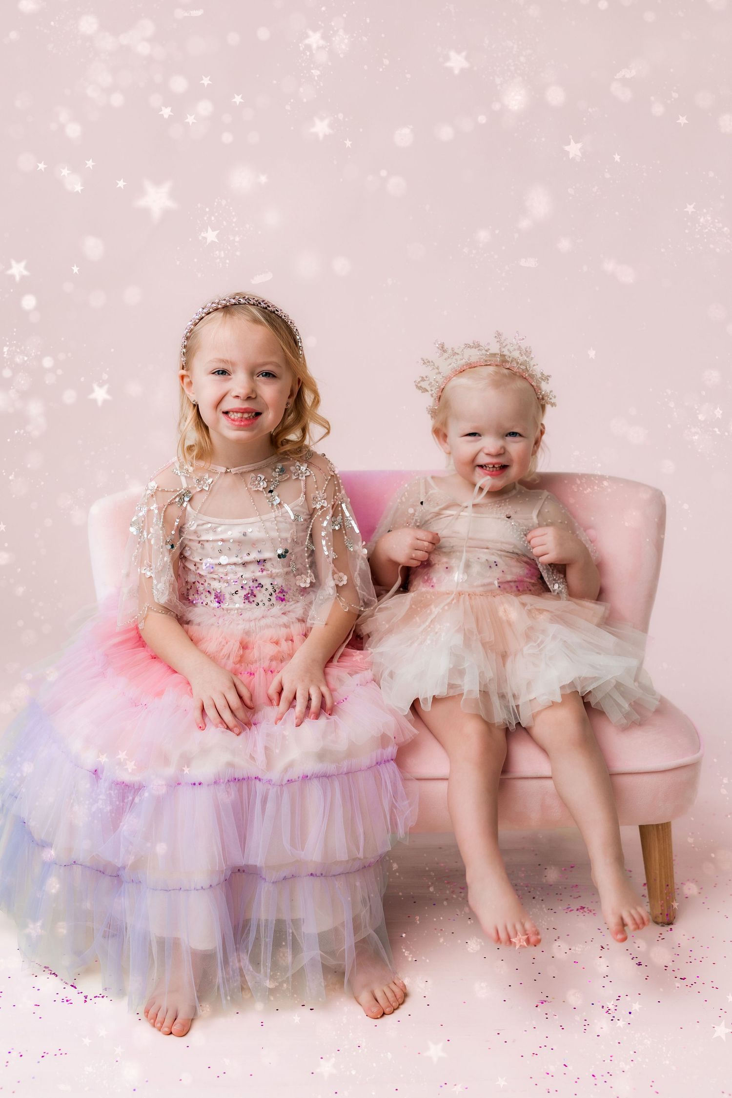two little girls dressed in dresses and tiaras