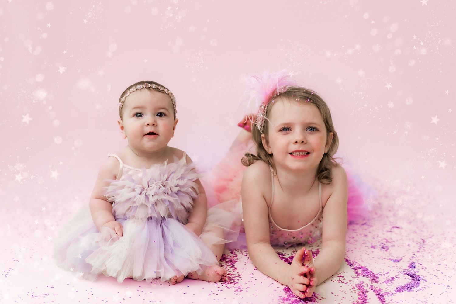 little girls sitting down with glitter all around