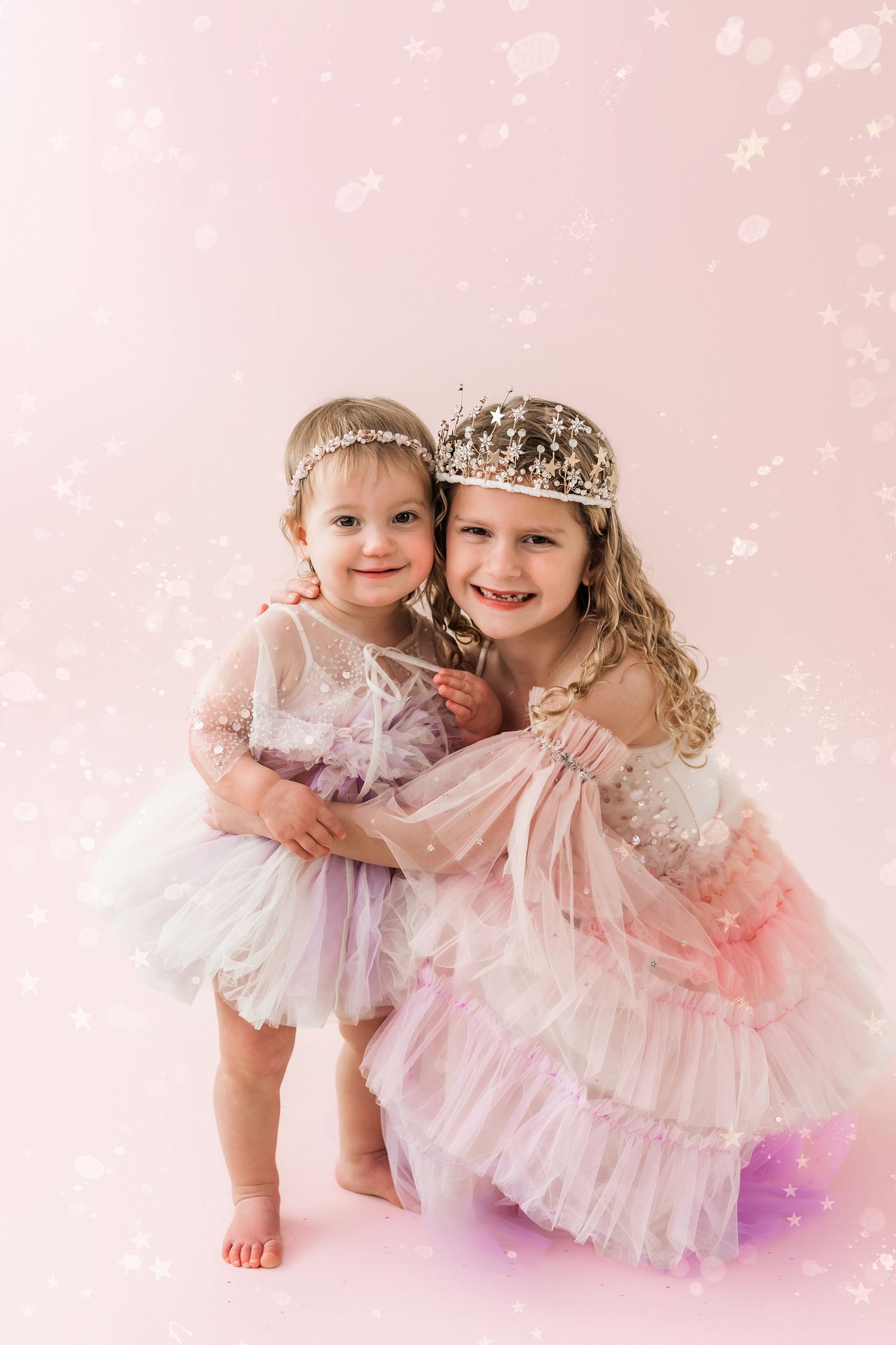 sisters hugging in front of a magical glitter background