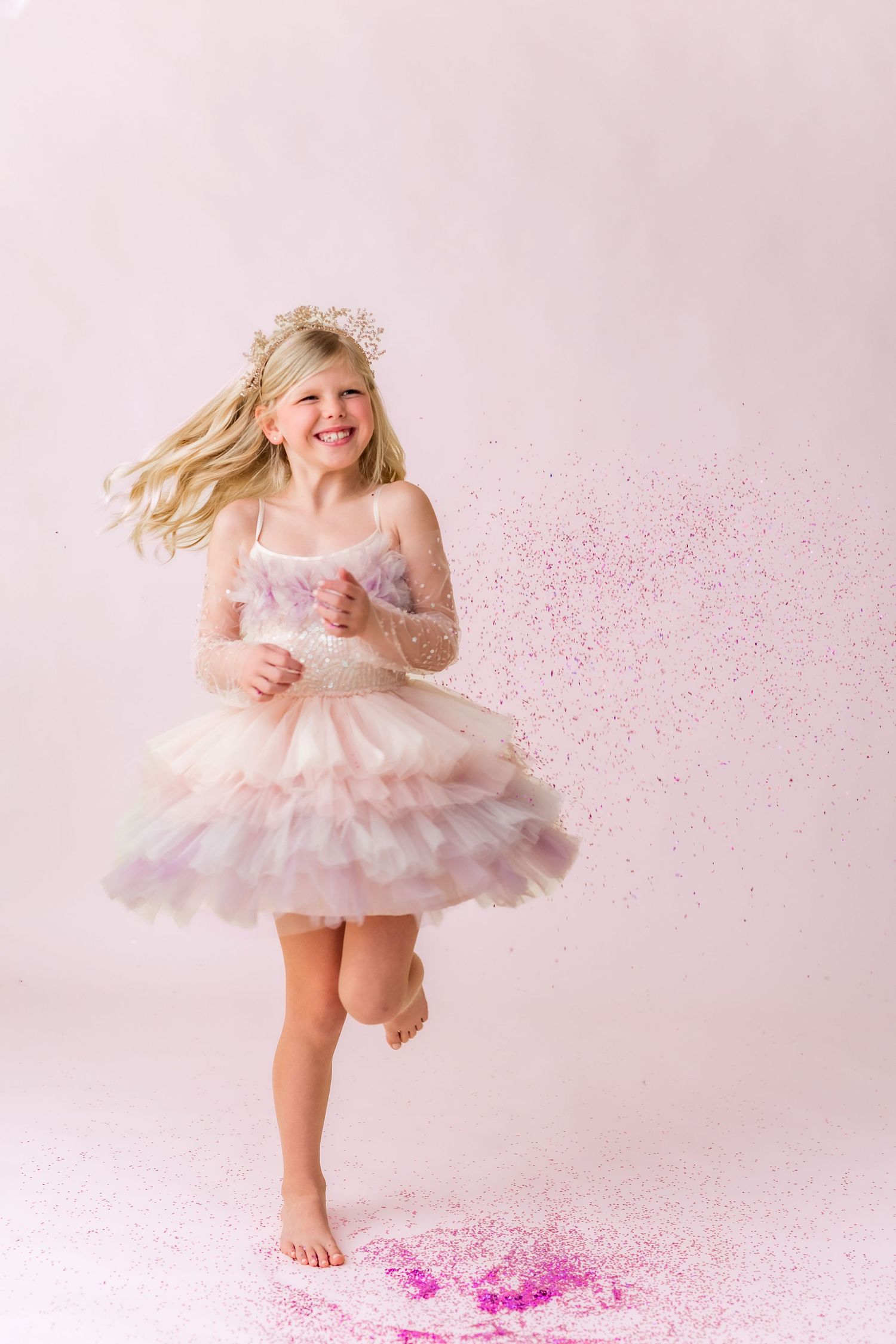 little girl twirling in a princess dress and tiara