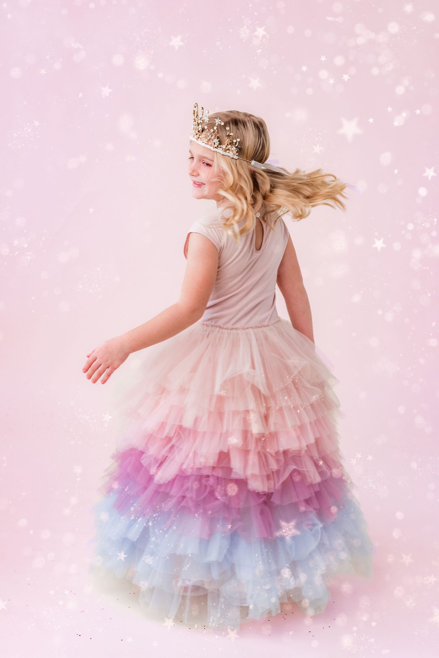 little girl in tiara twirling in pink glitter