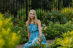 Strikingly colorful senior sits in a garden
