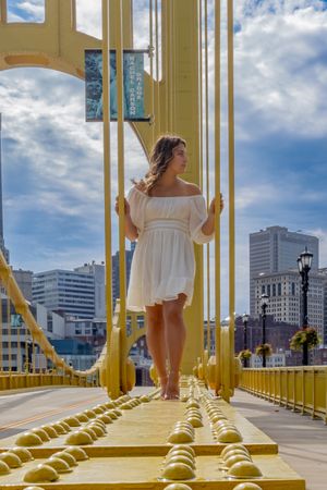 wow! this picture of a girl standing on a bridge is magazine ready!