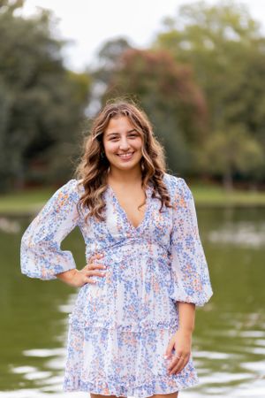 This classic hand-on-hip pose features a glistening pond and girl smiling widely