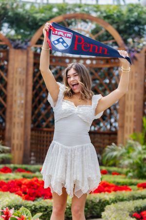 So excited to share her chosen college! This senior portrait features a girl holding up her university banner