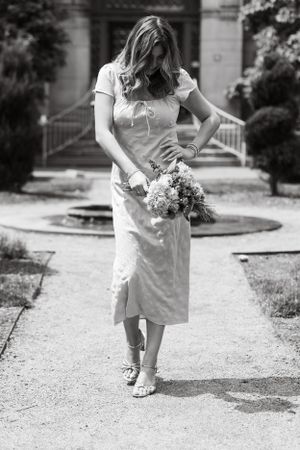 A one of a kind moment. Black and white image of girl walking with head down as she smiles shyly.