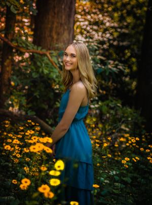 Wow! The colors in this senior portrait are absolutely gorgeous. Yellow flowers frame the girl standing in a field