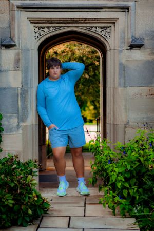 A magazine-like senior portrait of a young man looking like a model combing his hands through his hair