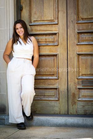 Nothing by attitude in this senior portrait of a girl posed against a wooden door.
