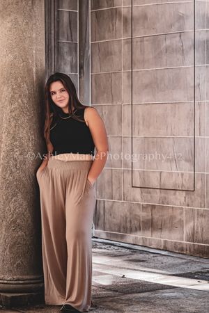 Very chic, this teenager leans against huge stone column looking ready for the runway