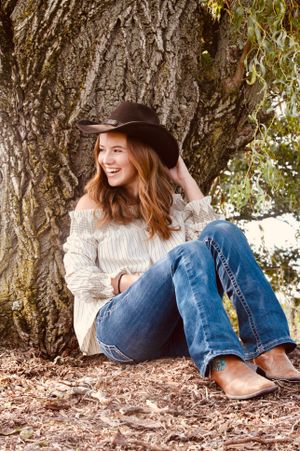 A weeping willow is the perfect place to pose for a seated senior portrait. This girl is home at her beautiful farm
