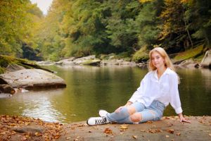 senior portrait; sitting posed photography; golden light and vibrant fall colors with a lake in the background