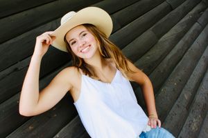 Posing with her cowgirl hat, this girl gives a flick of the brim