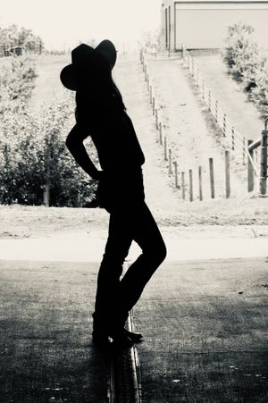 A shadowed image of a cowgirl