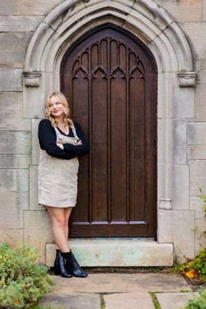 A wooden door is a great background for this senior portrait.