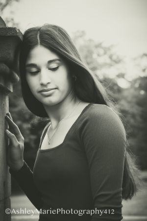 Stunning senior portrait gives vintage vibes. Girl looks down shyly away from the camera
