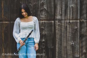 Bringing along her clarinet, this girl smiles casually at her instrument