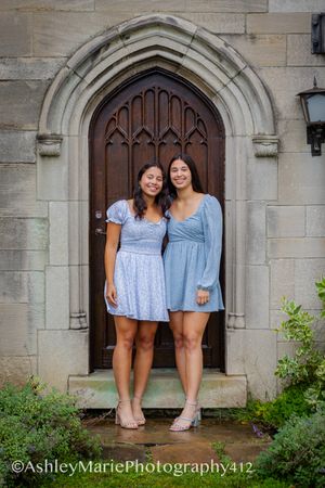 A wooden door is a great background for this senior portrait of two twins