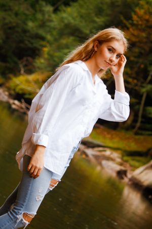 A girl tucks a strand of her hand behind her ears as the camera catches a coy glance