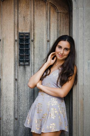 Nothing by attitude in this senior portrait of a girl posed against a wooden door.
