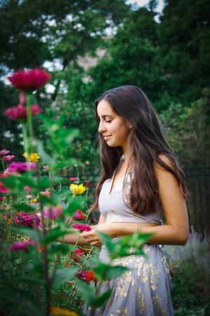 A girl picks colorful flowers in a garden. she is unaware of the camera