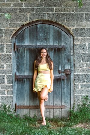 Nothing by attitude in this senior portrait of a girl posed against a wooden door.