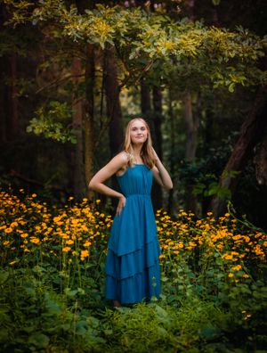 Wow! The colors in this senior portrait are absolutely gorgeous. Yellow flowers frame the girl standing in a field