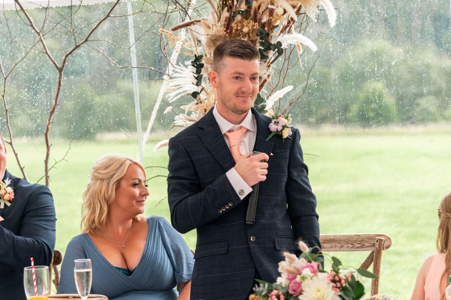Wedding guests socializing and celebrating at outdoor reception tables.