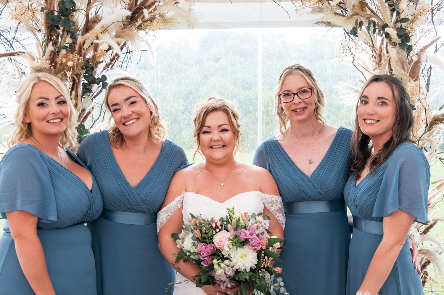 Wedding party in navy blue and white attire posing together outdoors.