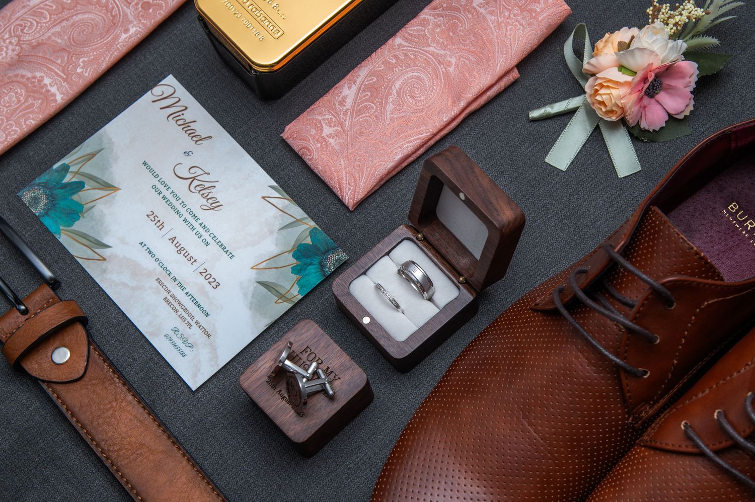 Wedding stationery and details arranged on pink and black surfaces.