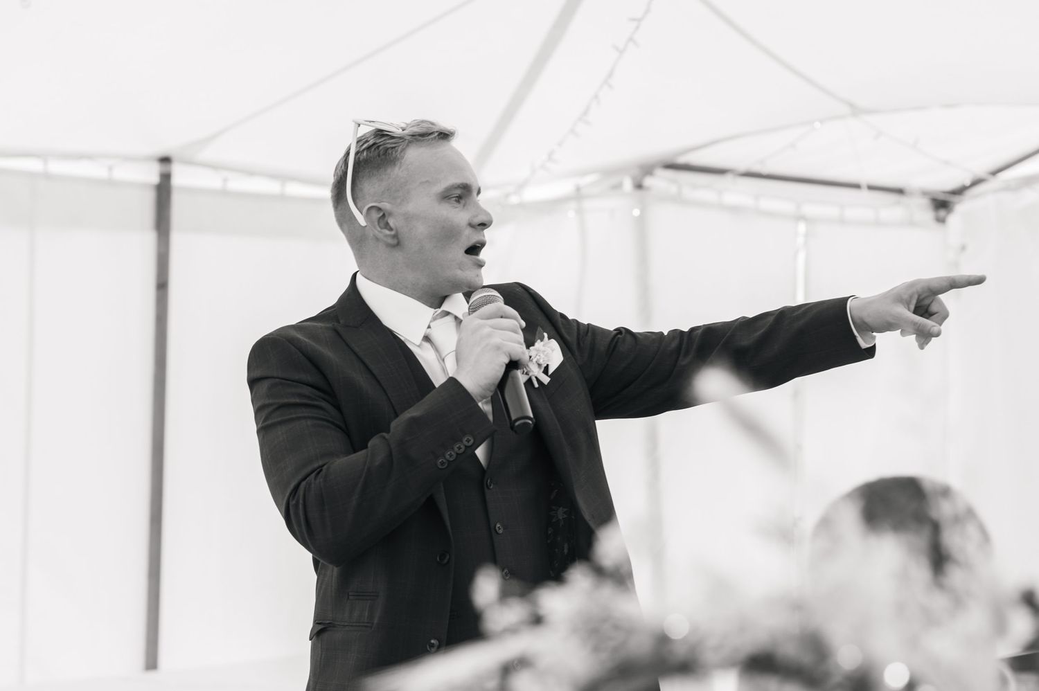 Black and white photos of guests gesturing and pointing during wedding celebrations.