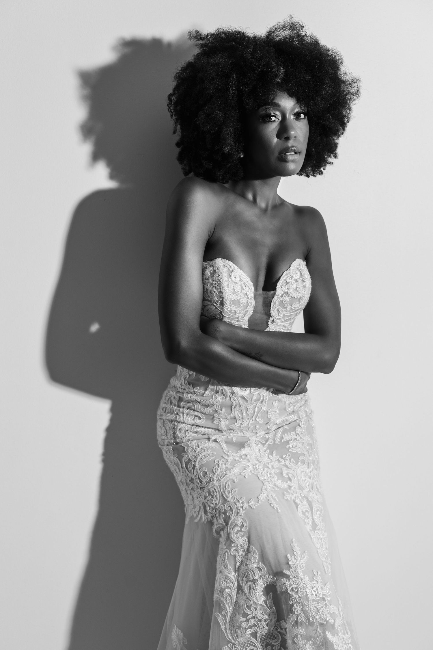 Dramatic black and white bridal portrait with shadow against white background.