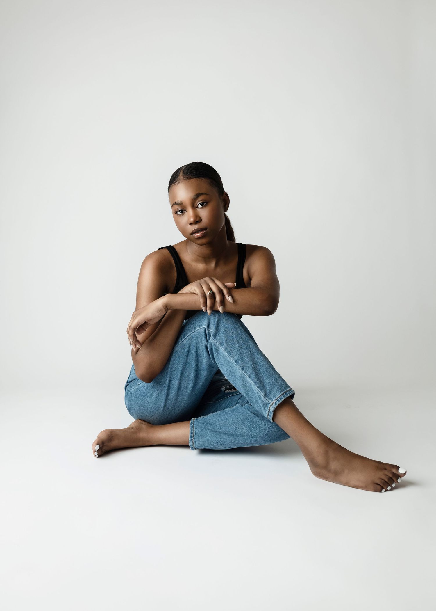 Minimalist portrait of model in casual denim against white background.