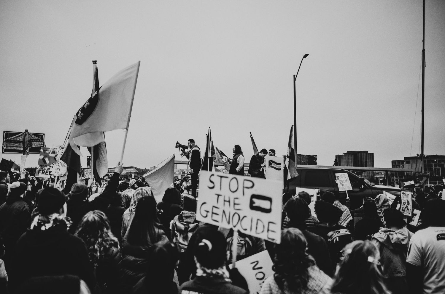 Pro Palestianian protesters rally around speaker on bridge in Portland, Oregon photojournalism kimberly marie kimble
