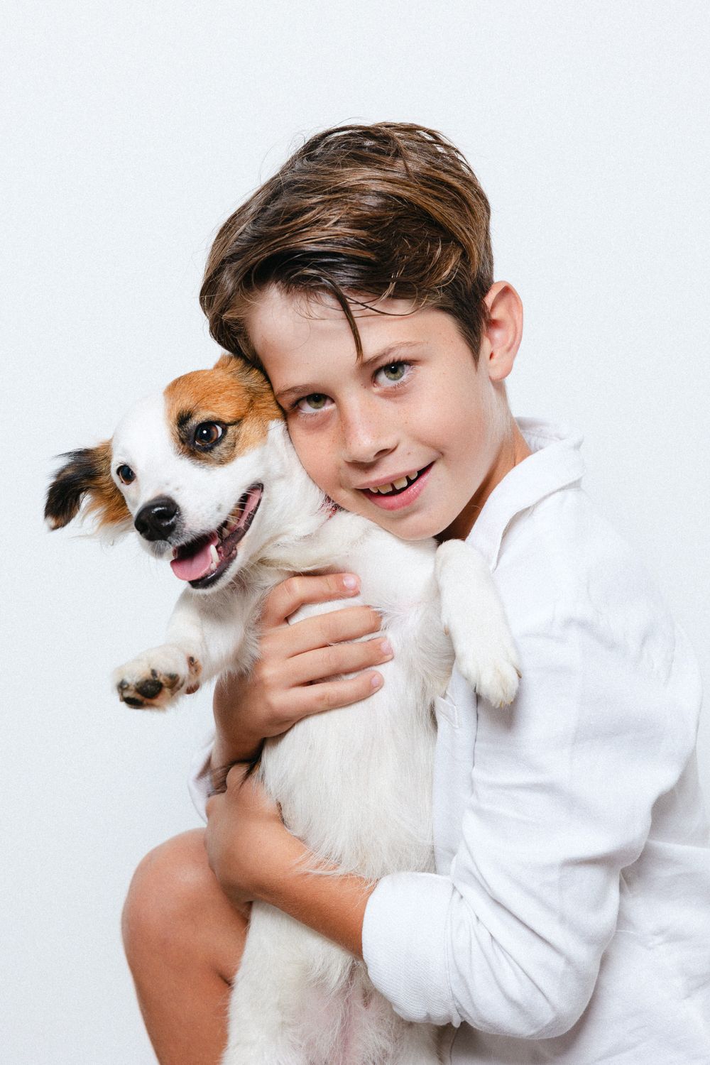 Playful photo sequence of a child hugging and interacting with a happy Jack Russell terrier.