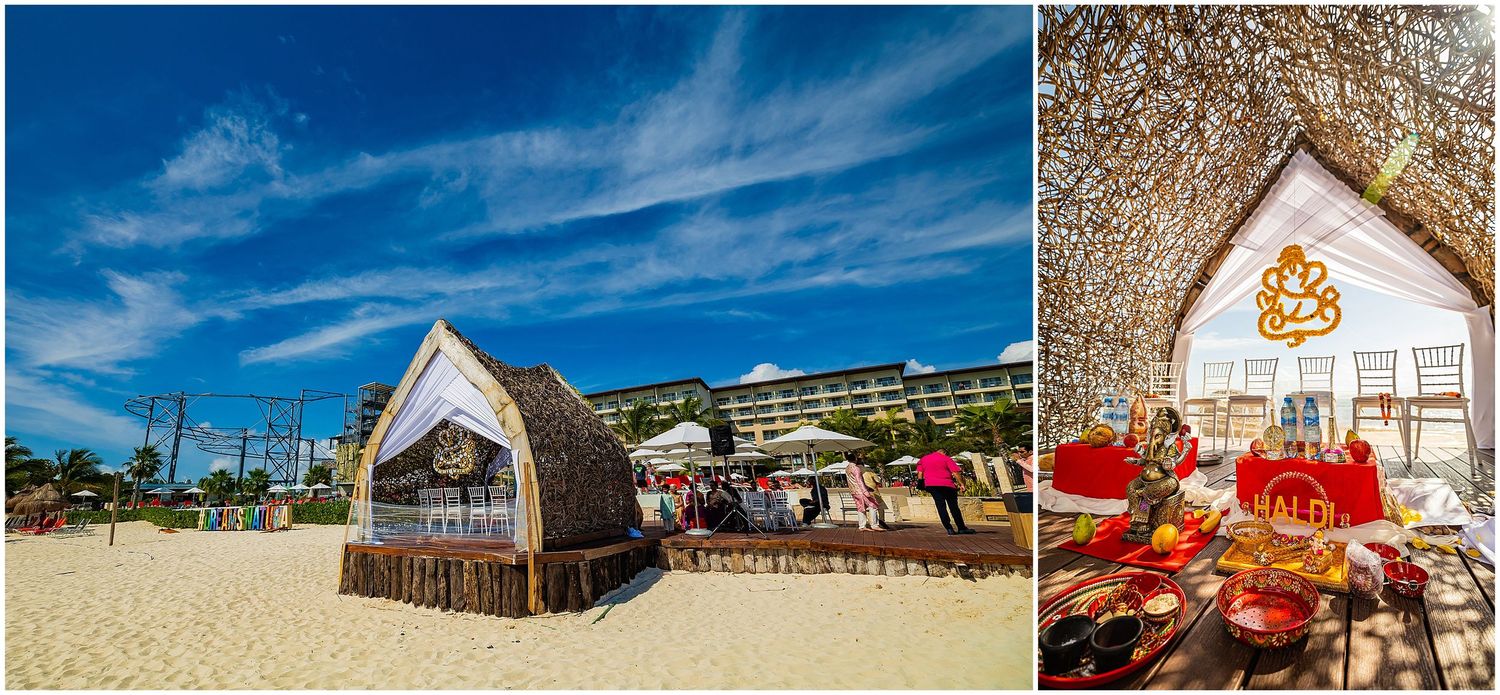 Beach wedding setup featuring wooden arch and traditional Indian decor elements.