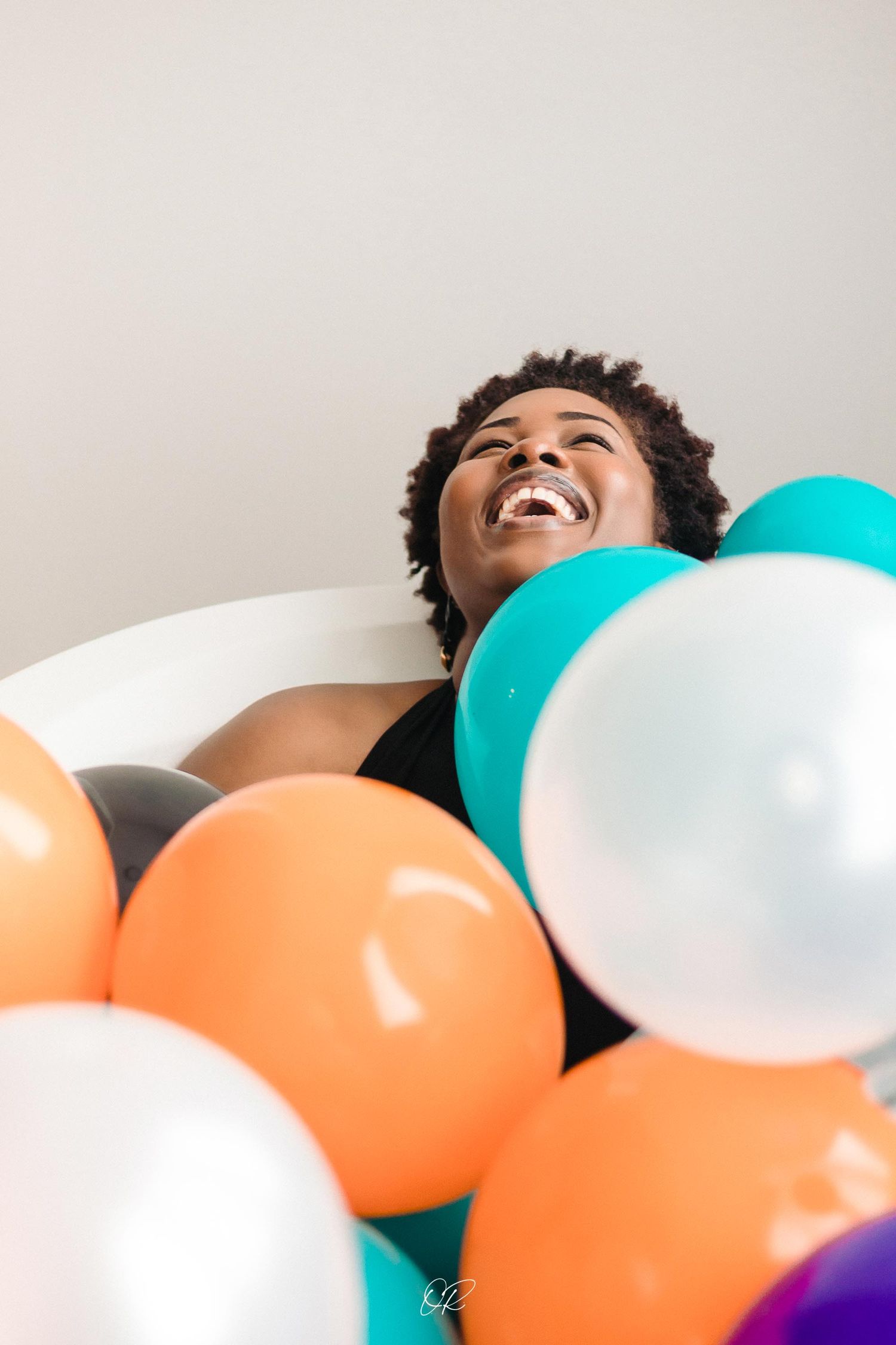Colorful party balloons in orange, teal, and white create a joyful celebration scene.