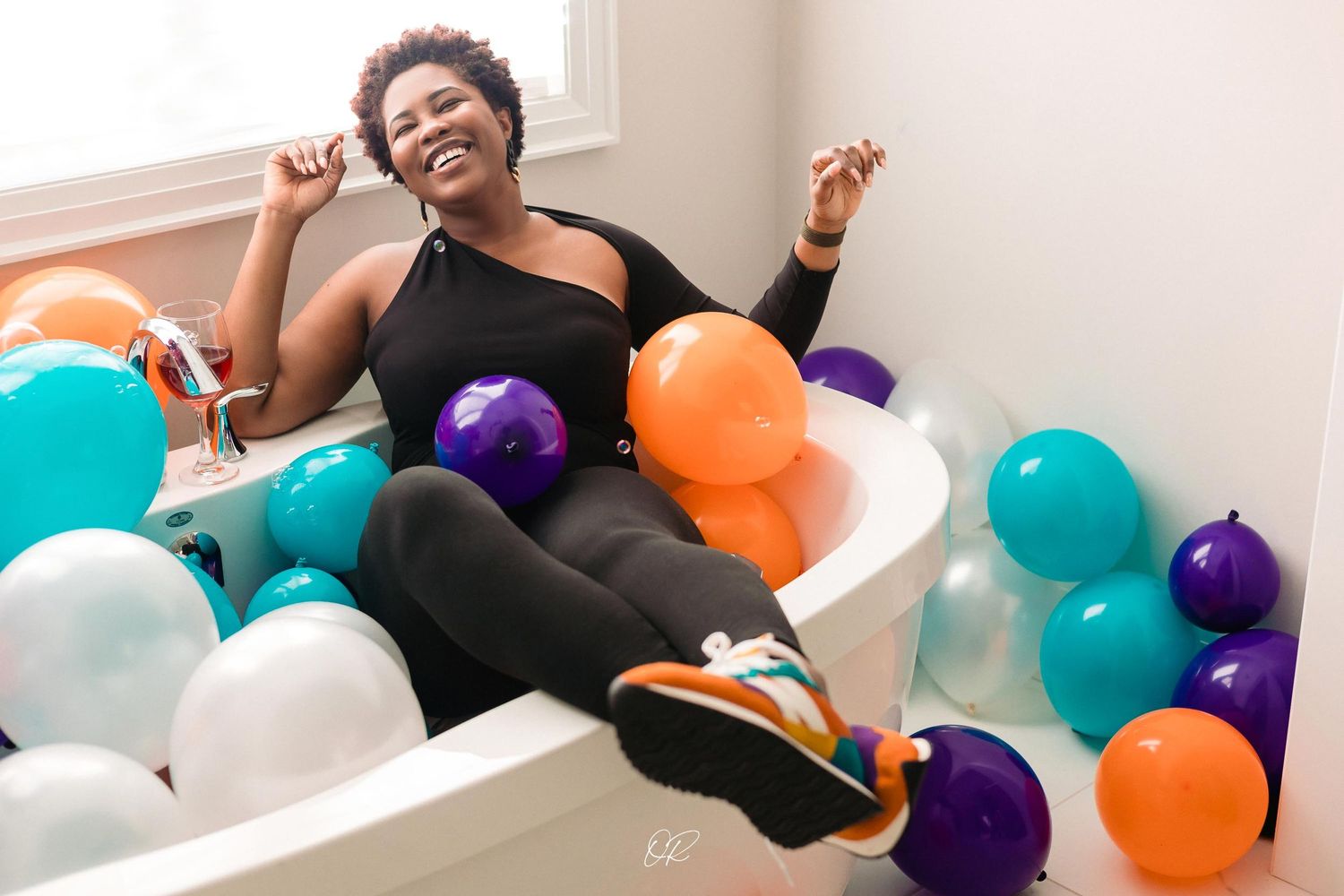 A festive setting with orange, purple, and teal balloons creates a celebratory atmosphere.