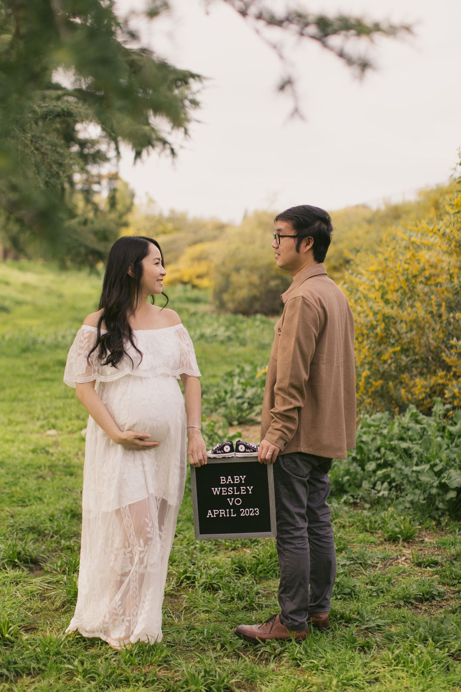 Maternity photo with couple holding letterboard announcing Baby Wesley Vo's arrival in April 2023.