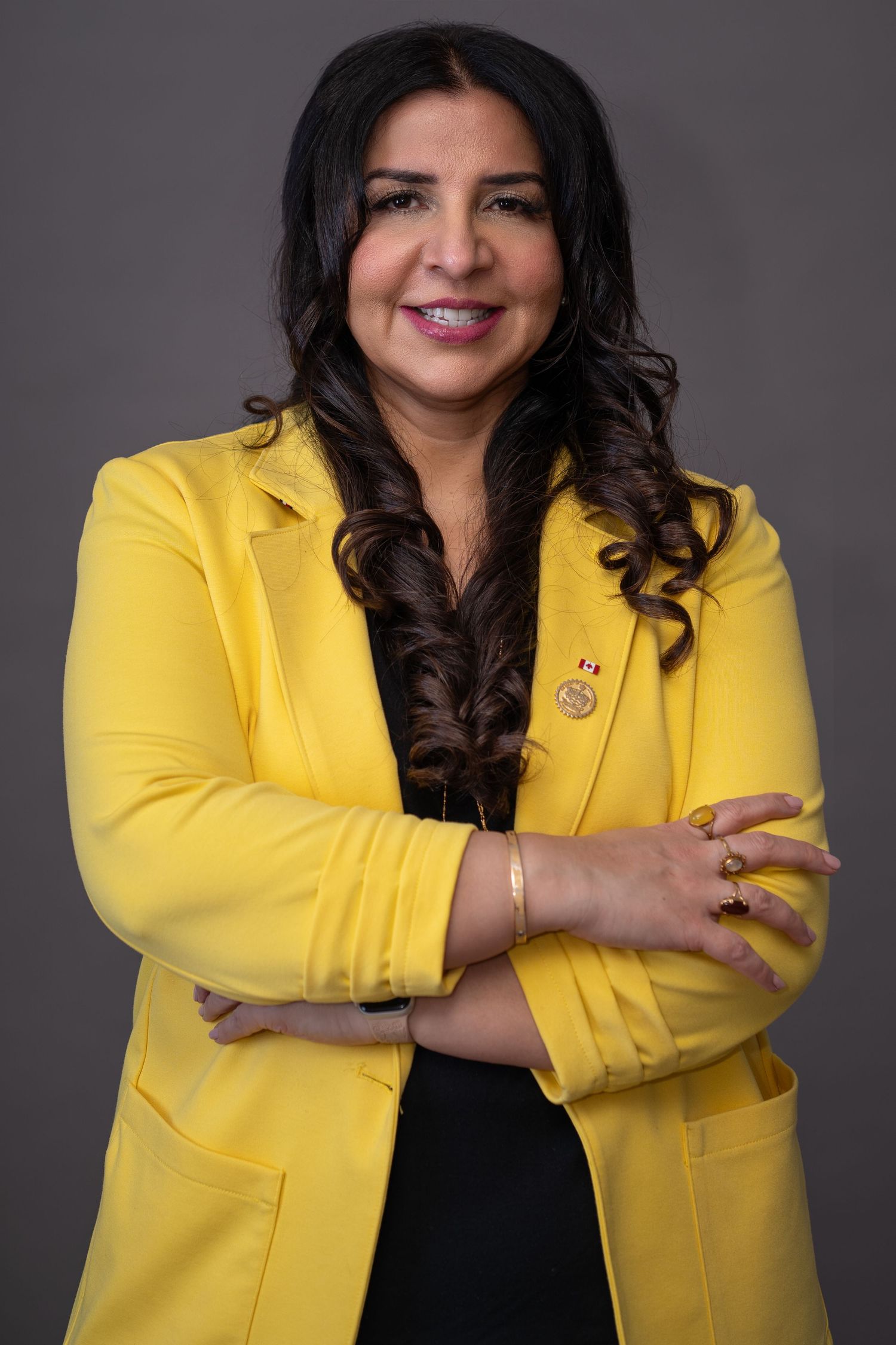 Confident business portrait of woman wearing bright yellow blazer.