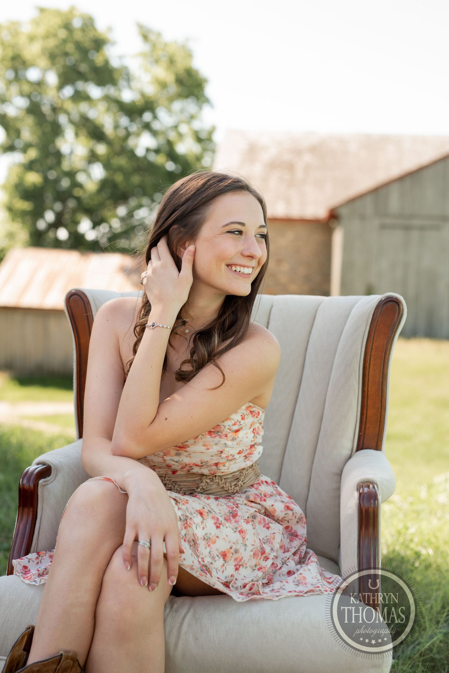 Candid moment in cream wingback chair with natural summer lighting.
