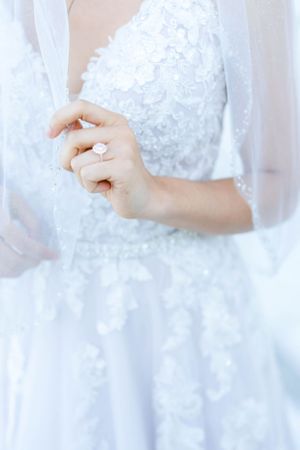 A close-up view of a woman's hand wearing a wedding ring.