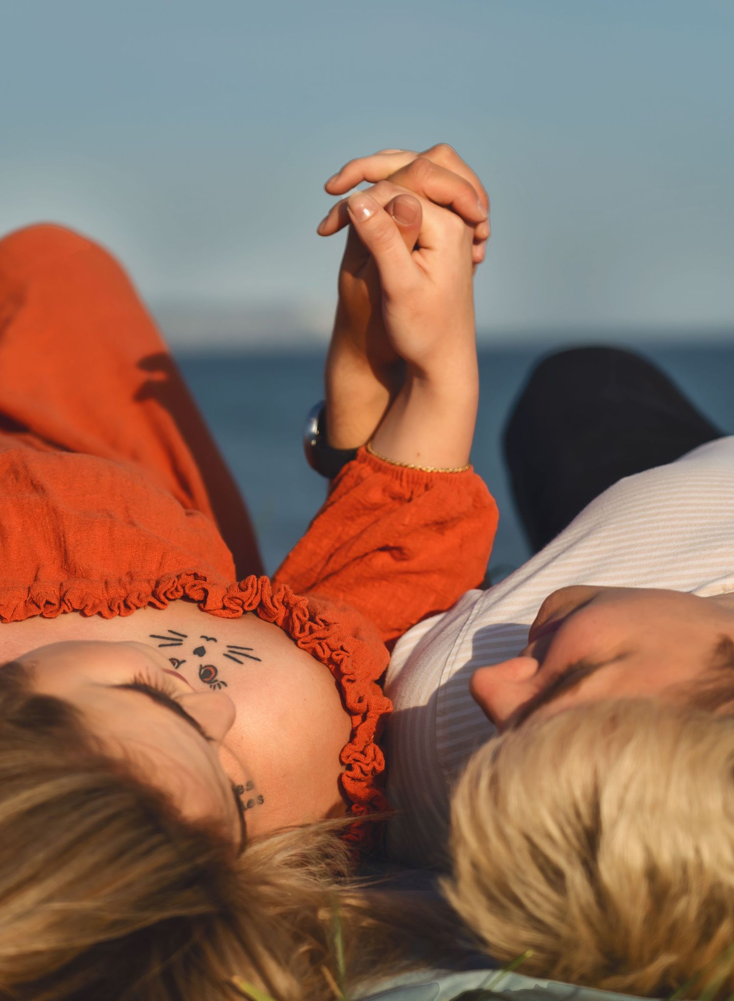 A couple holding hands and looking at each other at a photoshoot at the Hengistbury Head, Mudeford, Christchurch.