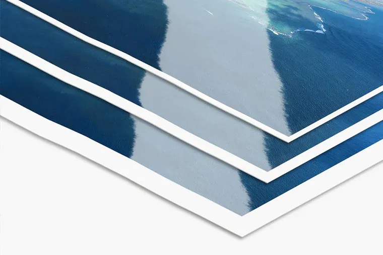 Close-up of layered photo prints showing white borders and glossy finish.