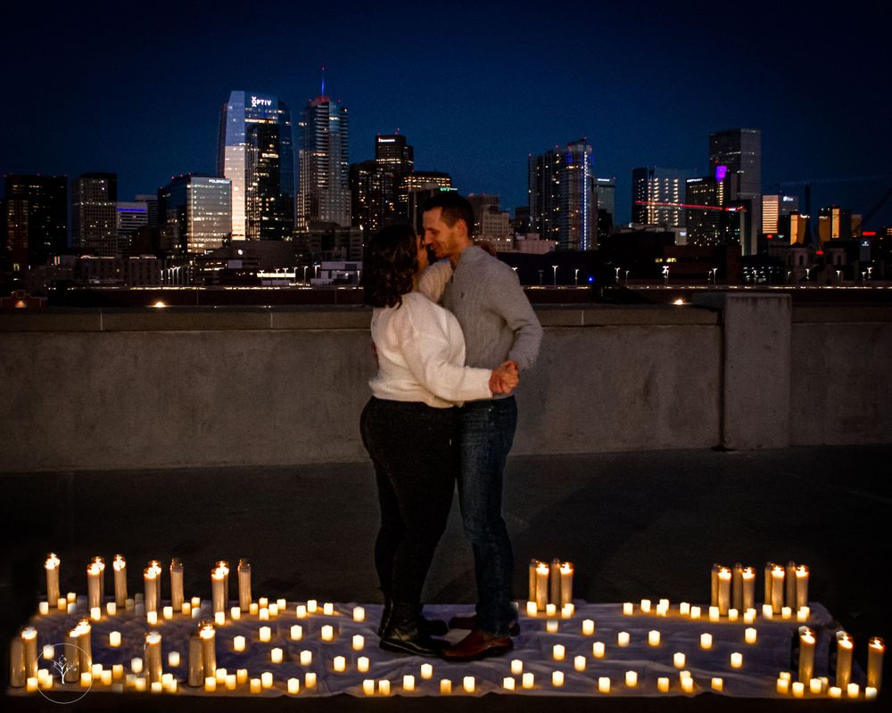 City skyline at night with illuminated buildings and romantic candlelit setting in foreground.