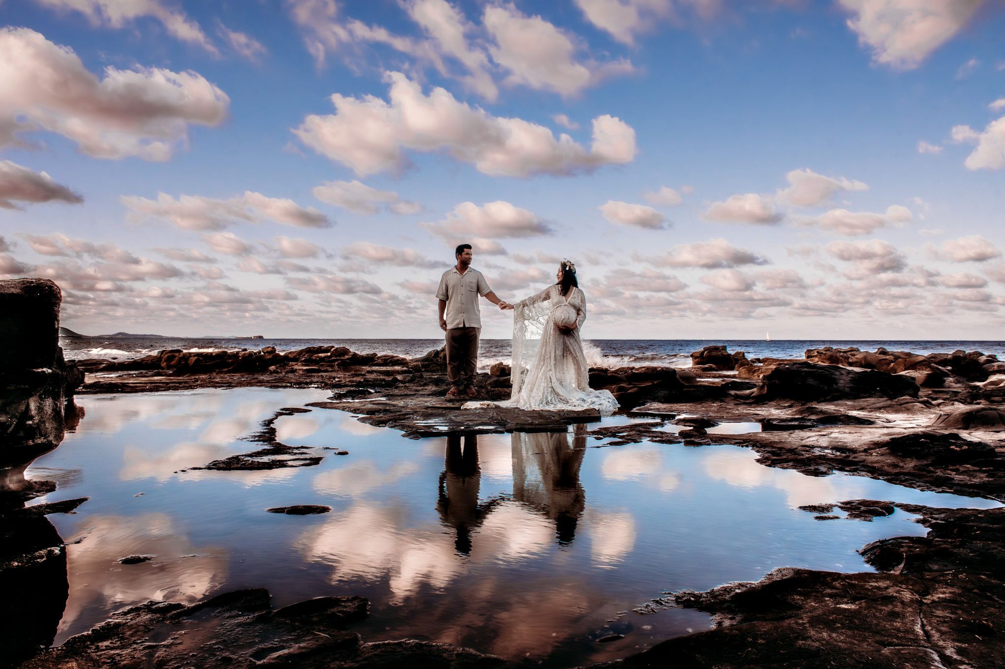 Dramatic beach photoshoot with reflections in tide pools at sunset.